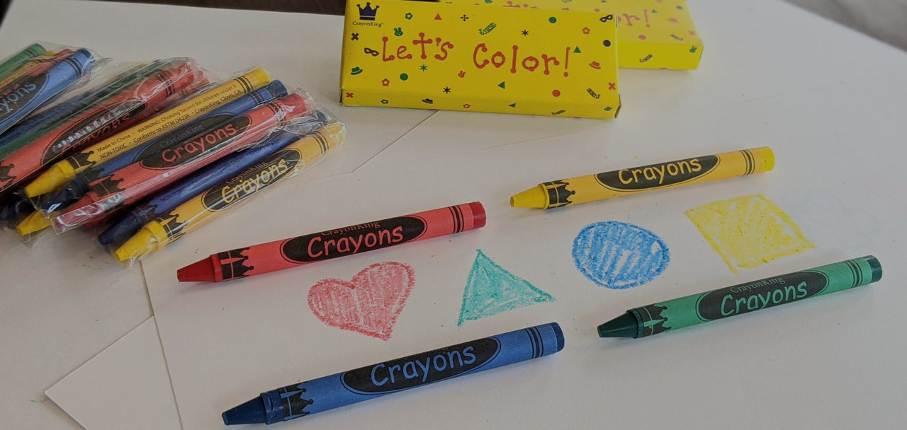 Photo showing red, green, blue, and yellow crayons; yellow "Let's Color" crayon box; and a kids color drawing.